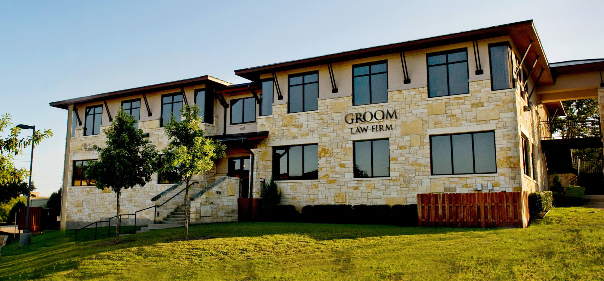 Exterior view of a modern stone and stucco building with groom's lawn room.